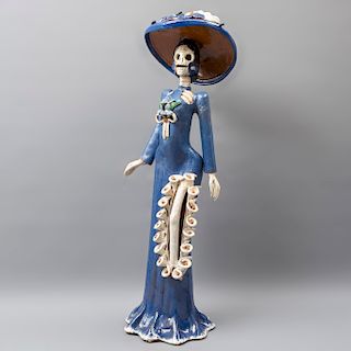 Catrina. México. SXX. En barro policromado y esmaltado. Cabeza desmontable. Vestida con vestido azul y sombrero. 71 x 23 x 20 cm.