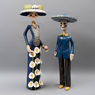 Catrina y Catrín. México. Siglo XX. En barro policromado y esmaltado. Cabezas desmontables. Vestidas. 59 x 18 cm. Ø (mayor)