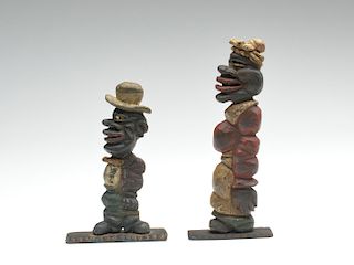 Two stylized carved black figurines.