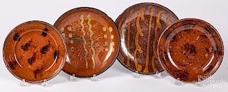 Four redware plates and shallow bowls