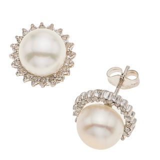 Par de broqueles con perlas y diamantes en oro blanco de 14k. 2 perlas color blanco de 7 mm. 40 acentos de diamantes. Peso: 2....
