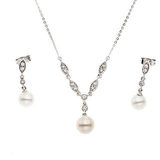 Collar con pendiente y par de aretes con perlas y diamantes en oro blanco de 14k. 3 perlas color blanco de 7 mm. 16 diamantes co...