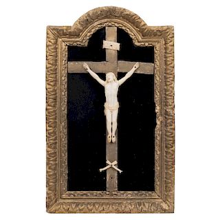 CHRIST ON THE CROSS. MEXICO, 19TH CENTURY. Ivory carving on Latin wooden cross. In carved and gilded wooden frame, decorated with vegetal motifs. 16 x