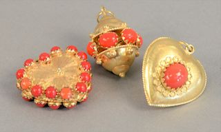 Three large 18K gold charms with red stones, 35.7 grams total weight.