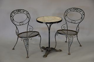 Six piece lot to include four iron chairs and two bistro tables with stone tops and iron bases (tops cracked). ht. 28 in., dia. 20 in.