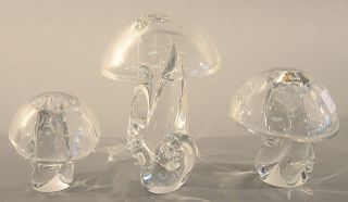 Four piece Steuben group to include set of three crystal Steuben mushrooms, smooth capped, three sizes (tallest ht. 8 in.) along with a small snail (h