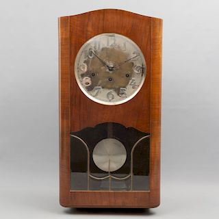 Reloj de pared. Siglo XX. En talla de madera. Mecanismo de cuerda y péndulo. Puerta abatible con cristal biselado. 65 x 33 x 20 cm.