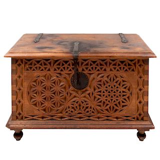 Baúl. Siglo XX. Estilo marroquí. Elaborado en madera tallada con aplicaciones de herrería. Con tapa abatible.