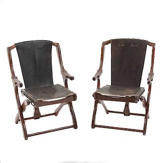 Par de sillas. Marca Don S. Shoemaker. Estados Unidos. Siglo XX. En talla de madera. Con respaldos y asientos en piel.