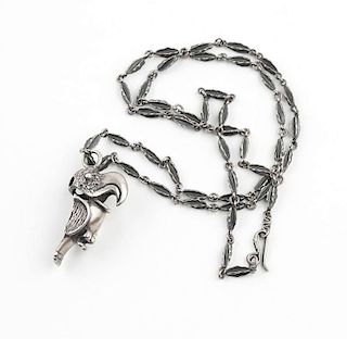 A silver parrot pendant with carved silver chain