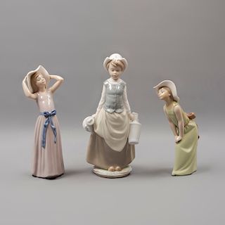 Lote de 3 figuras decorativas. España. Ca. 1960. En porcelana Lladró. Consta de: niña con cántaros y 2 niñas con sombrero.