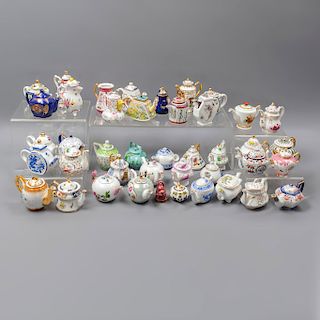 Lote de 42 teteras pequeño formato. Diferentes orígenes, marcas y diseños. Siglo XX. Elaboradas en porcelana, cerámica y cloisonné.