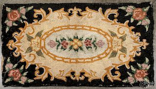 American hooked rug, early 20th c., in a floral pattern, 34'' x 57''.