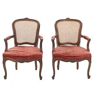 Par de sillones. SXX. En talla de madera. Con respaldos de bejuco, asiento en tapicería color vino.
