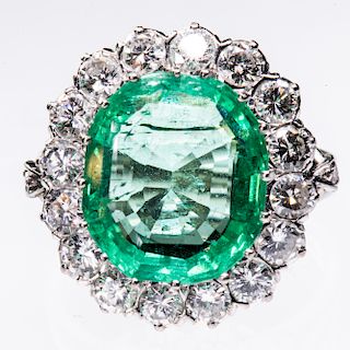 AN EMERALD AND DIAMOND CLUSTER RING, the large oval cut eme