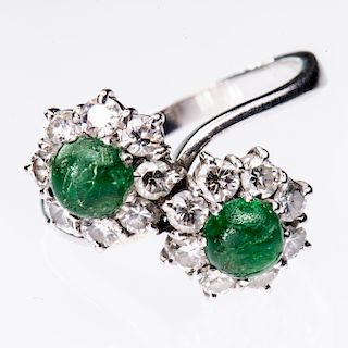 AN EMERALD AND DIAMOND RING, the cross over style mount set