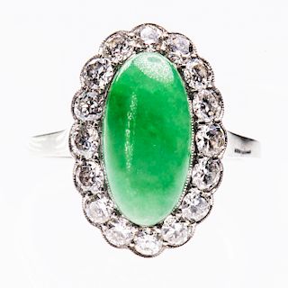 A JADE AND DIAMOND RING, the oval cabochon cut jade set wit