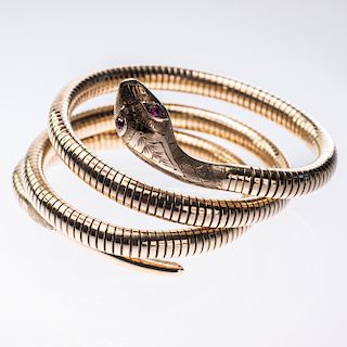 A 9CT YELLOW GOLD SNAKE BANGLE, the body coiled to create t