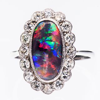 A PLATINUM, BLACK OPAL AND DIAMOND RING, the oval cut opal 