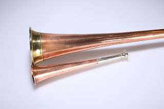 AN EDWARDIAN COPPER COACHING HORN AND A COPPER HUNTING HORN
