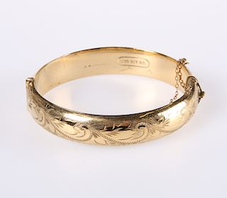 A LATE VICTORIAN GOLD-PLATED BANGLE, hinged, one half with 