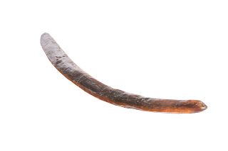 A CHIP-CARVED BOOMERANG, undecorated. 64cm