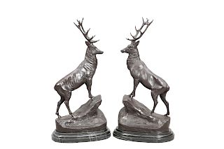 A LARGE PAIR OF BRONZE STAGS, each modelled standing on a r