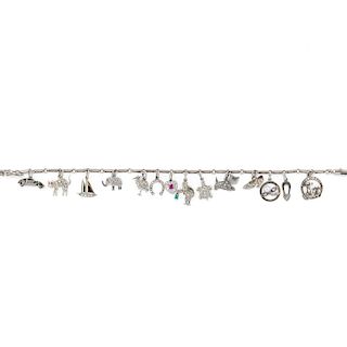 A platinum, 18K and 9K white gold and diamond bracelet with charms 