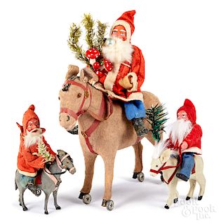 Three composition Santa Claus figures on donkeys
