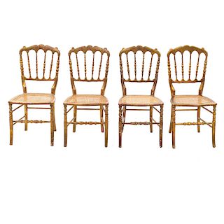 Lote de 4 sillas. Siglo XX. Elaboradas en madera dorada. Con respaldos semiabiertos y asientos de bejuco.