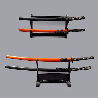 Lote de 2 pares de katanas. Japón. Siglo XX. Elaboradas en acero. Color anaranjado y negro. Con bases de madera.