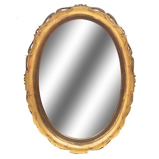 Espejo. Siglo XX. Dise–o oval. En talla de madera dorada. Con luna biselada. Decorado con elementos org‡nicos. 97 x 69 x 8 cm.