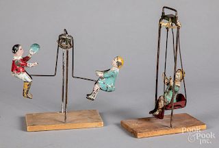 Two painted tin swinging toys