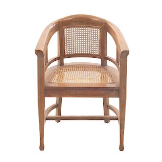 Sillón. Francia. Siglo XX. En talla de madera de nogal. Con respaldo y asiento de bejuco y fustes lisos.