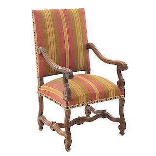 Sillón. Francia. Siglo XX. En talla de madera de roble. Con respaldo cerrado y asiento acojinado en tapicería rayada.