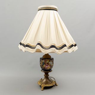 Lámpara de mesa. Origen europeo. SXX. En porcelana tipo Sèvres y metal dorado. Electrificada para una luz. 60 x 42 cm. Ø