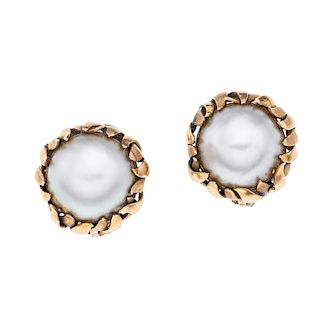 Par de aretes con medias perlas en oro amarillo de 14k. 2 medias perlas cultivadas color gris de 15 mm. Peso: 15.9 g.