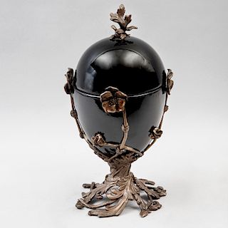 Urna. Siglo XX. Elaborada en cerámica color negro, acabado vidriado con aplicaciones de bronce. Decorada con motivos florales.