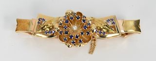 14 Karat Gold Bracelet, having three dimensional flower with blue sapphires and diamond center with sectioned band. length 6 1/2 inches, 37.8 grams.