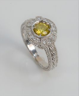14 Karat White Gold Ring Set with Canary Yellow Diamond, approximately 1 carat, surrounded by small diamonds. size 6 1/4 inches.