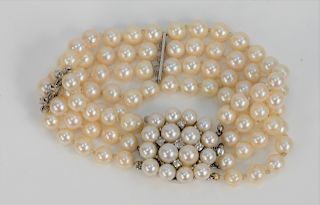 Pearl and Diamond Bracelet, having four strands 6.7 millimeter pearl and nine small diamonds attached with round 14 karat white gold clasp set with pe