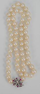 Single Strand of Pearls, with 14 karat white gold clasp set with six small rubies and center diamond. length 25 inches, average 8.8 millimeter pearls.