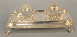 A George III Silver Inkstand, London 1764, the oblong stand on four paw feet, engraved with central crest, fitted for two cut glass bottles. height 3 