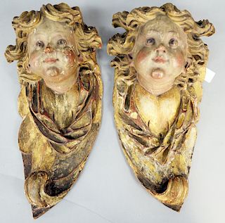 Pair of Carved Putti Faces, with original polychrome decoration, 18th century or later (one lower edge side missing). height 18 1/2 inches.