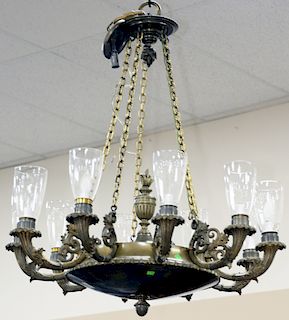 A Empire Bronze Ten Light Oil Lamp Chandelier, circular body with flame form finial and mounted with ten foliate scroll cornucopia lights, previously 