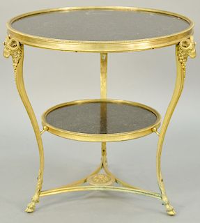 Louis XVI Style Gilt Bronze Gueridon Table, round two tier with black granite, having gilt bronze rams head and hairy hoof feet, possibly gueridons. h