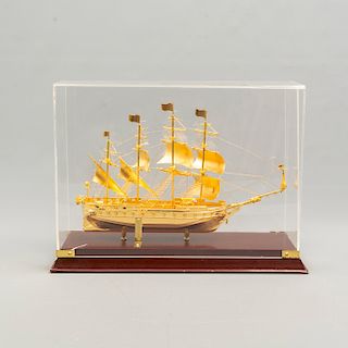 Galeón. México. Siglo XX. Diseño a escala. Elaborado en metal dorado. Hutchison Ports México. Con base y capelo. 28 x 39 x 14 cm.