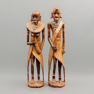 Pareja de ídolos africanos. Siglo XX. En madera policromada. Decorados con joyería elaborada con chaquiras y cuentas. 63 x 15 x 9 cm.