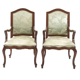 Par de sillones. Siglo XX. En talla de madera. Con respaldos cerrados y asientos en tapicería floral verde.