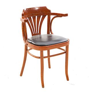 Sillón. Siglo XX. En talla de madera. Con respaldo semiabierto, asiento en vinipiel color negro, chambrana en "O".